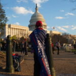 A Donald Trump supporter, draped in a 'Keep America Great' flag, demonstrating against the presidential election results in 2020.